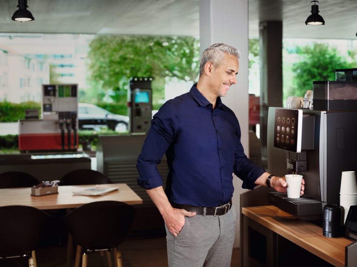 Man zet een kopje koffie bij een koffiemachine voor bedrijven