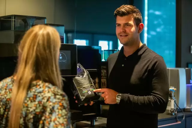 Koffie adviseeur geeft advies in koffiemachine showroom in lijnden over zakelijke koffiemachines