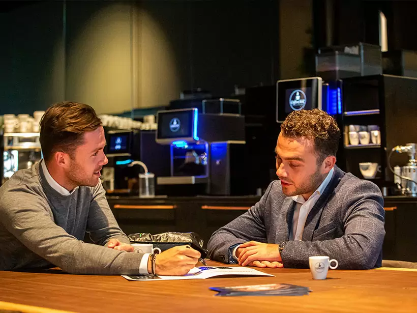 In overleg met de klant over een koffiecontract.